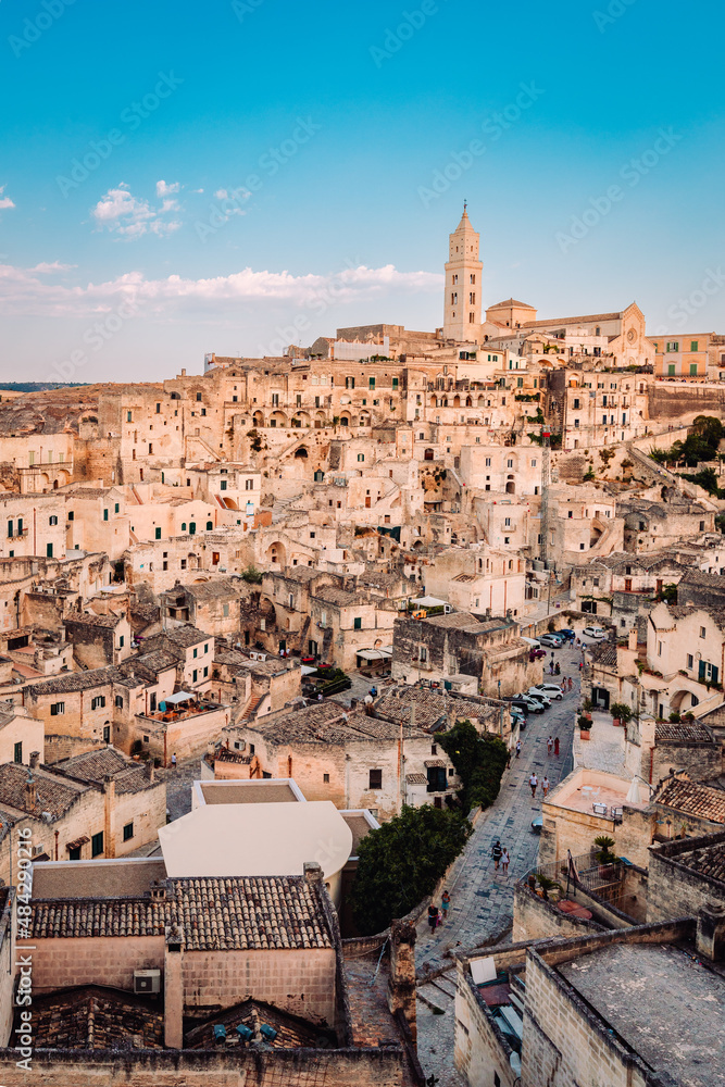 View of the Sassi di Matera from the Belvedere di San Pietro Barisano, blue sky with clouds, vertical