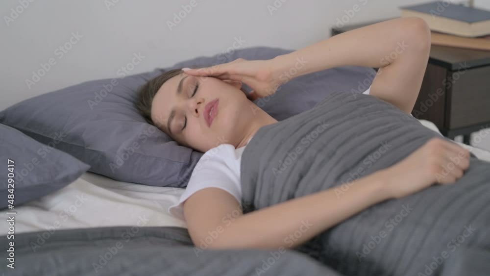 Woman having Headache while Sleeping in Bed Woman having Headache while Sleeping in Bed