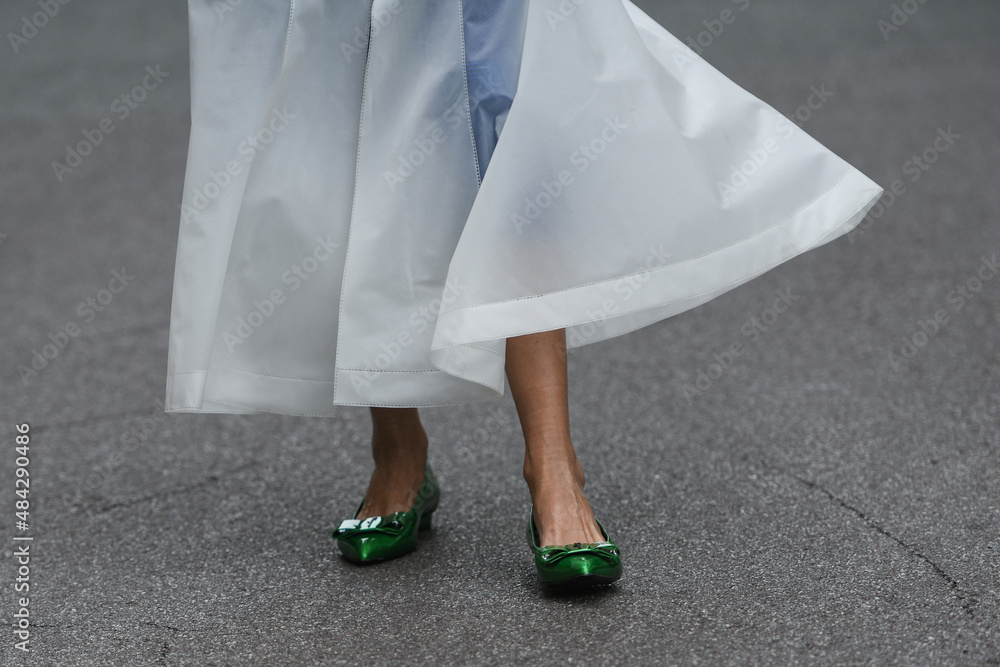woman wearing shiny dark green shoes and white transparent dress
