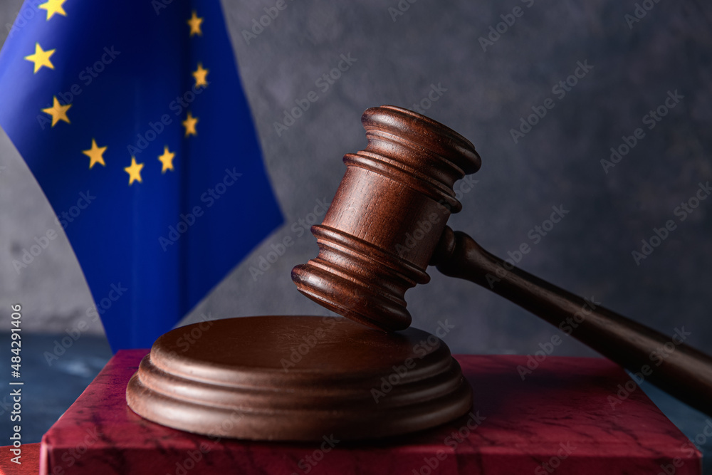 Gavel of judge with book and European Union flag on dark background