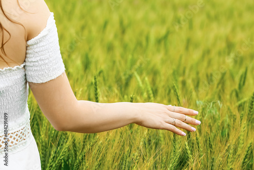 Woman in green wheat field, closeup