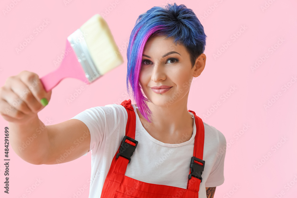 Female painter with brush on pink background Female painter with brush on pink background