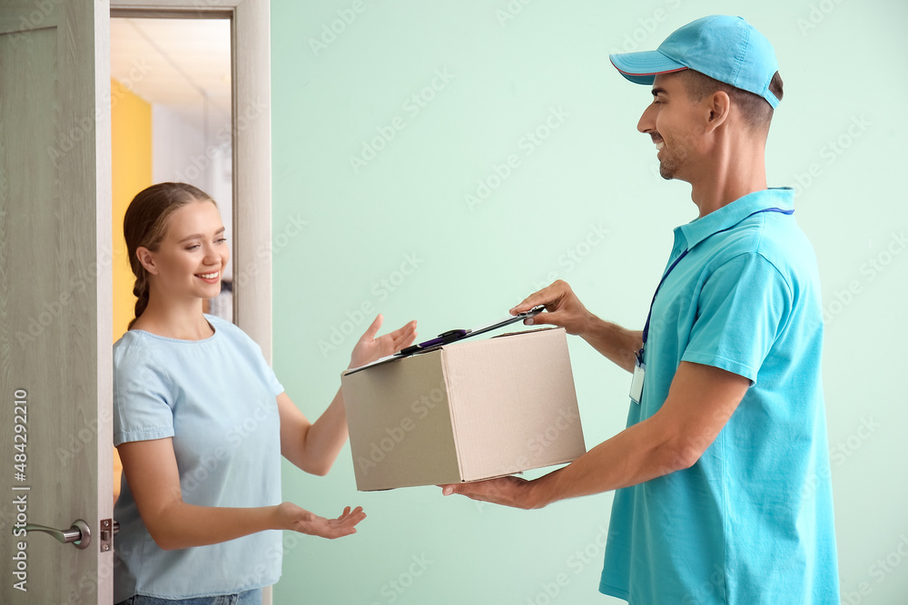 Young woman receiving parcel from courier of delivery company Young woman receiving parcel from courier of delivery company
