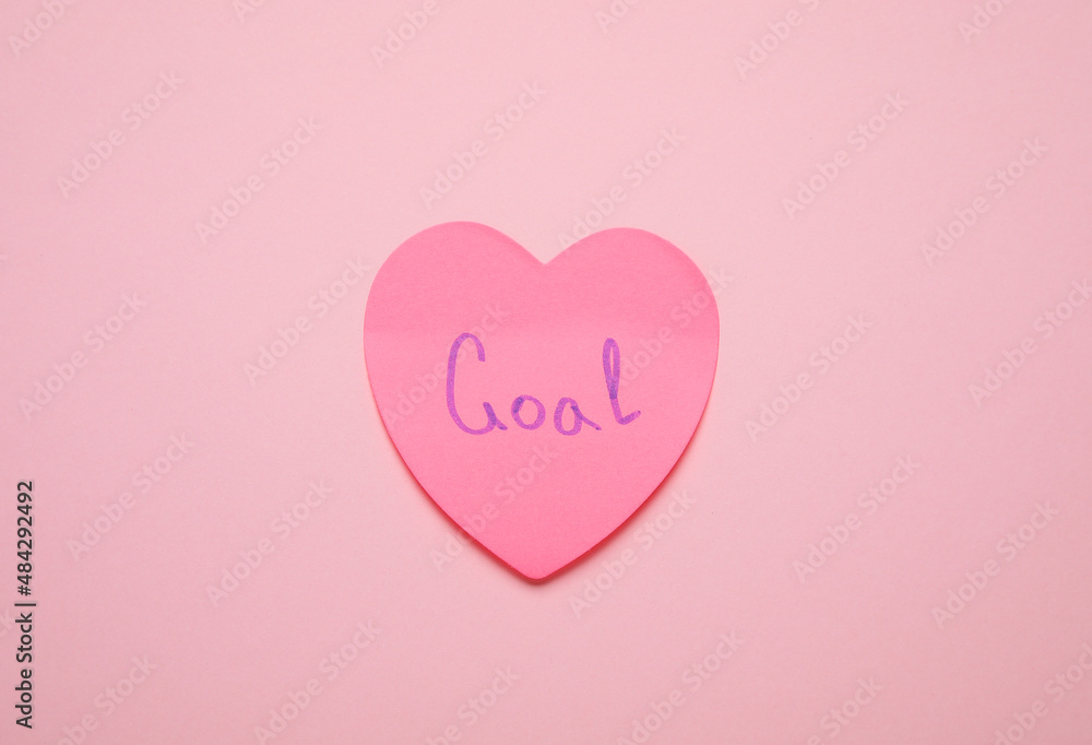 Heart shaped sticky note with word GOAL on pink background