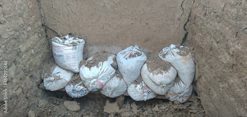 Pile of bags in an old house built with mud bricks and straw.