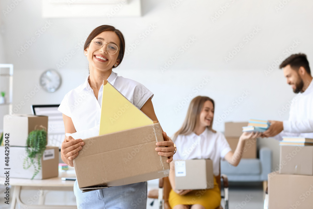 Beautiful woman holding box with things in office on moving day Beautiful woman holding box with things in office on moving day