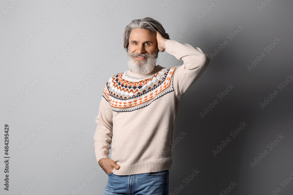Handsome senior man in knitted sweater on grey background Handsome senior man in knitted sweater on grey background
