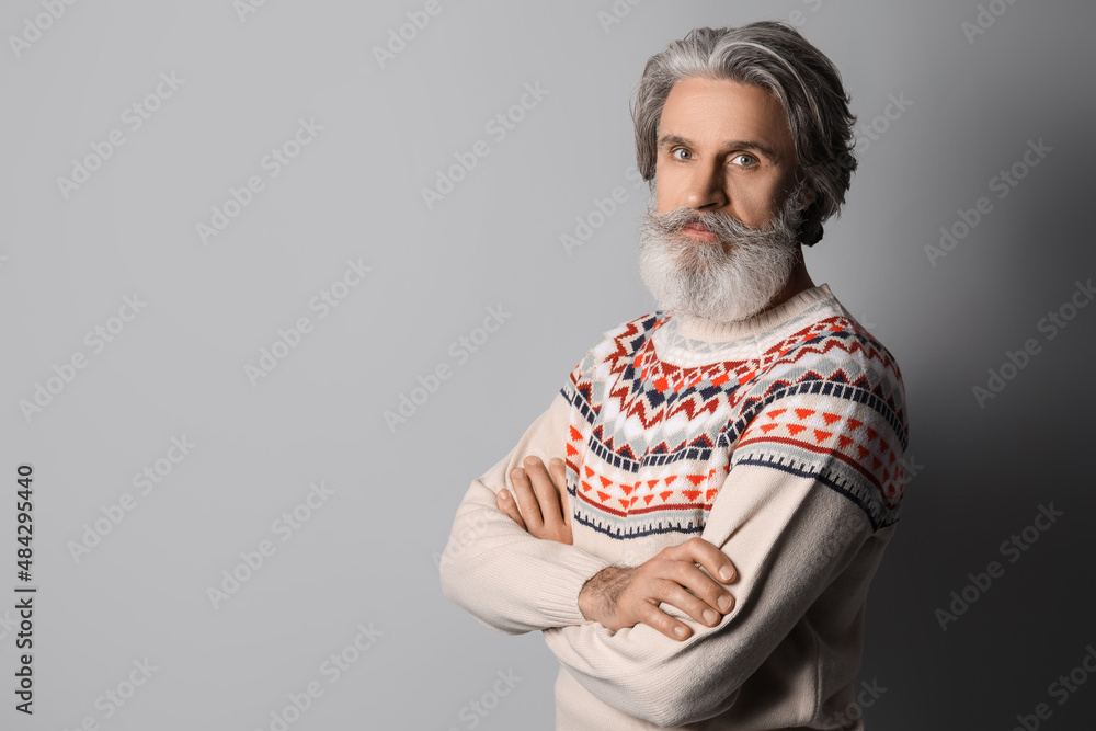 Fototapeta premium Handsome senior man in knitted sweater on grey background
