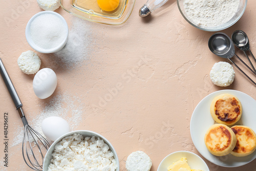 Frame made of tasty cottage cheese pancakes and ingredients on beige background