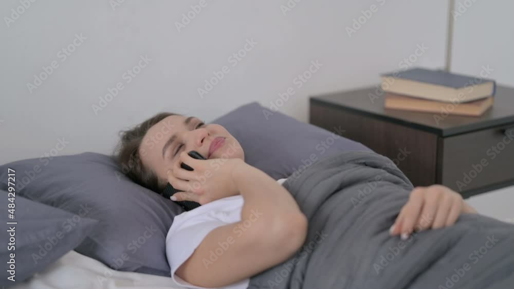 Woman Talking on Smartphone while Sleeping in Bed Woman Talking on Smartphone while Sleeping in Bed