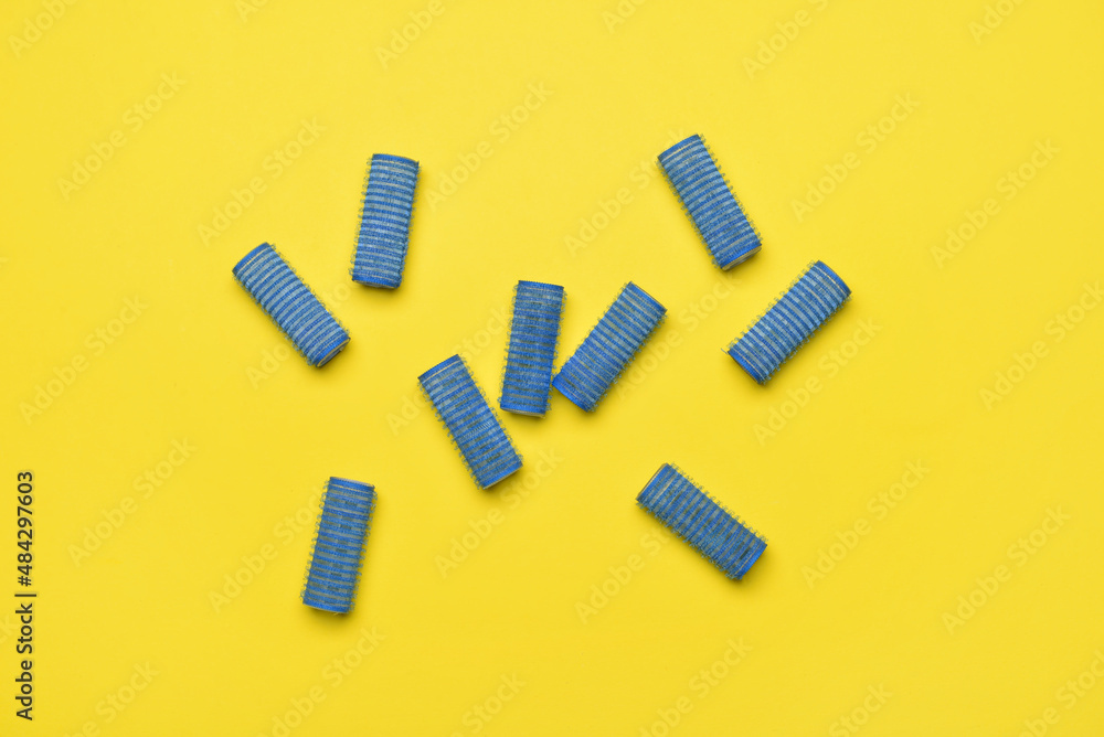 Blue hair curlers on yellow background Blue hair curlers on yellow background