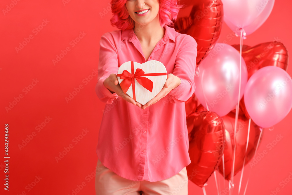 Stylish woman with bright hair, gift and air balloons on color background. Valentine's Day celebration Stylish woman with bright hair, gift and air balloons on color background. Valentine's Day celebration