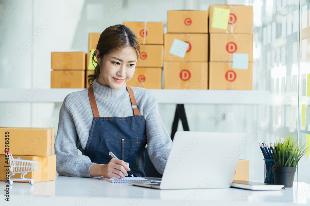 woman writing on box of parcel preparing to delivery, business online concept