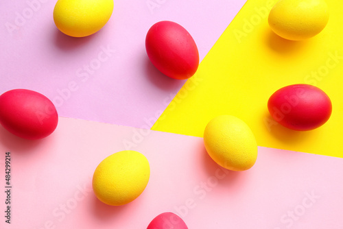 Red and yellow Easter eggs on color background