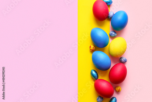 Different painted Easter eggs on color background