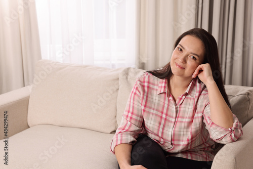 Beautiful overweight woman sitting on sofa at home Free Download Beautiful overweight woman sitting on sofa at home - GFXLoad