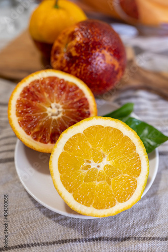 Sicilian sweet juicy yellow and red blood oranges with green leaves close up