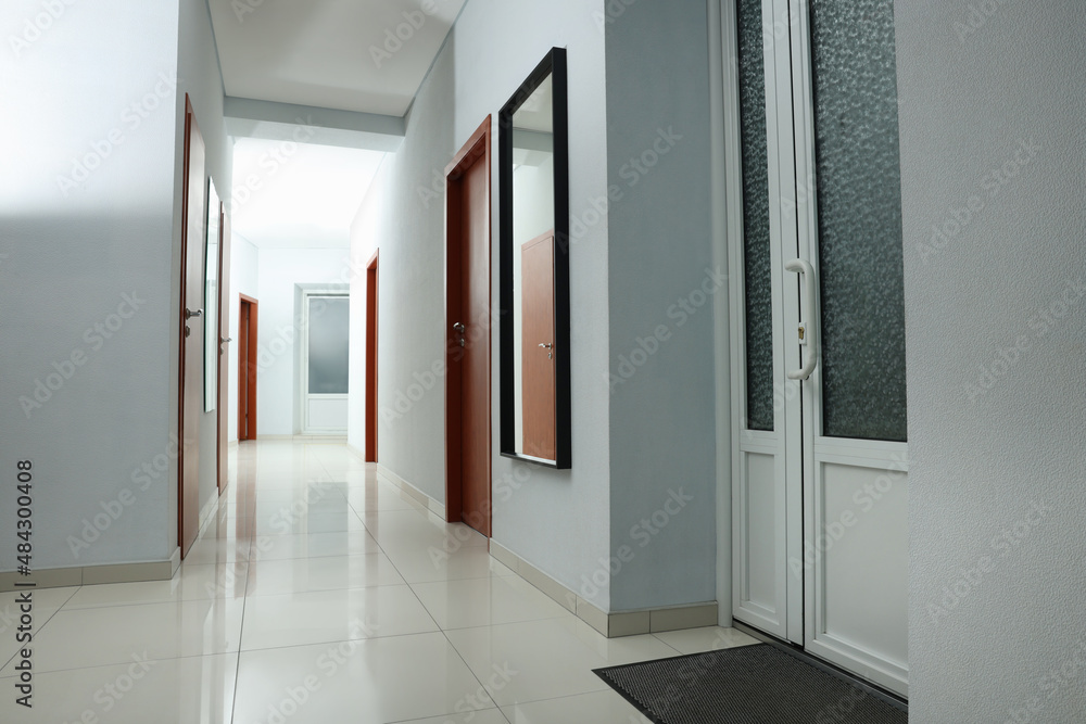Modern empty office corridor with white walls and mirror Modern empty office corridor with white walls and mirror