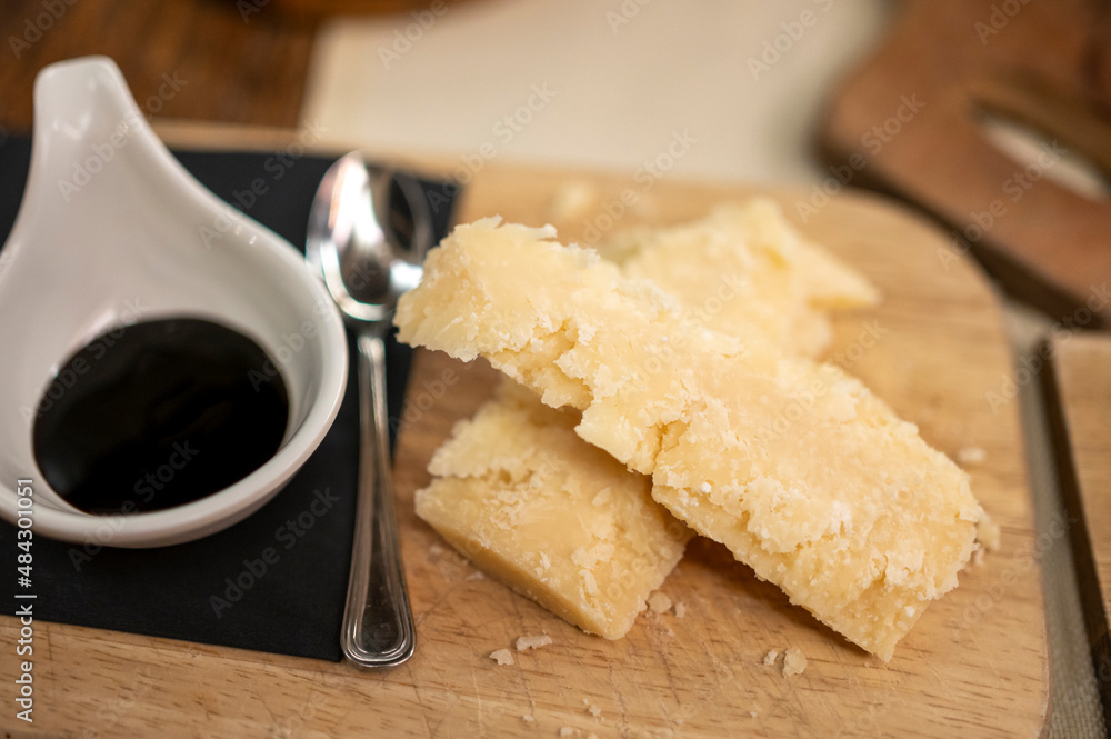 Tasting of different matured and very old parmesan Parmigiano-Reggiano hard cheese and balsamic vinegar of Modena in Parma, Emilia Romagna, Italy