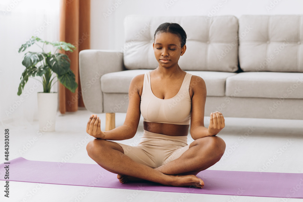 Young black woman meditating at home, yoga online concept, free space Young black woman meditating at home, yoga online concept, free space
