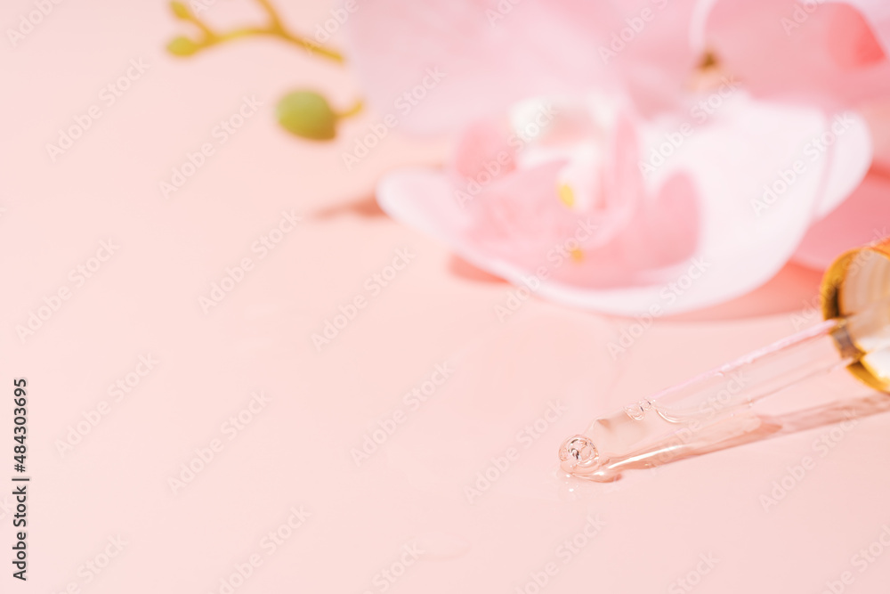 Orchid and pipette filled with liquid on pink background. Orchid and pipette filled with liquid on pink background.