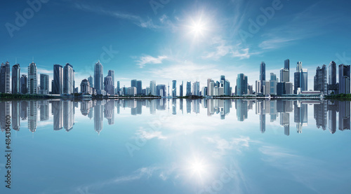 Blue tone panorama of waterfront city skyline with reflection. Image composite.