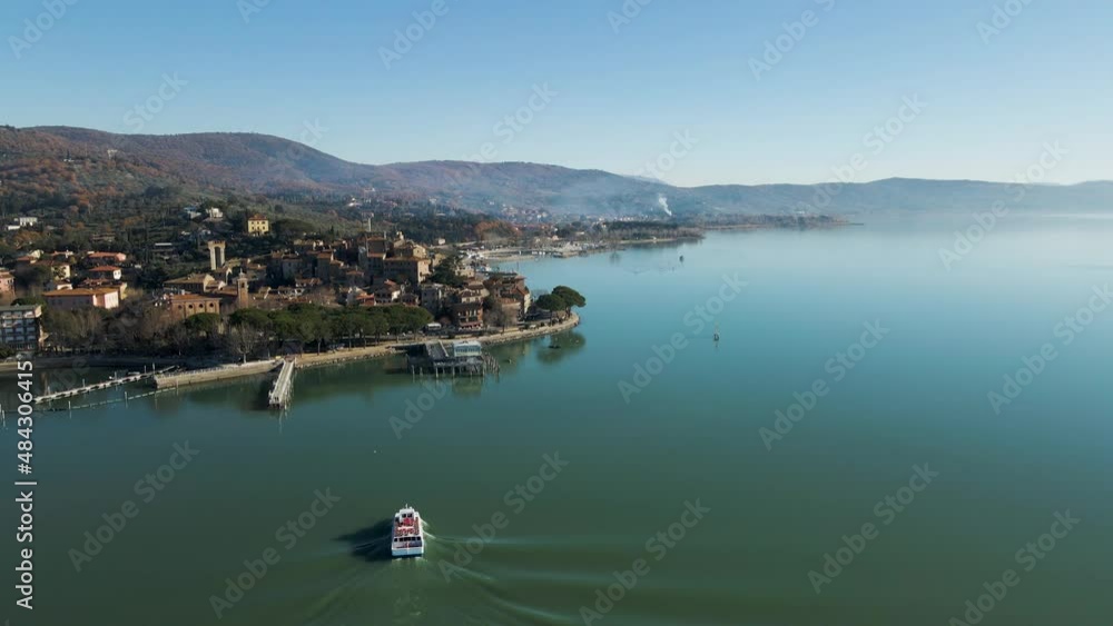 Aerial view of a sailing boat navigating on Passignano sul Trasimeno, a beautiful lake near Perugia, Umbria, Italy. Aerial view of a sailing boat navigating on Passignano sul Trasimeno, a beautiful lake near Perugia, Umbria, Italy.