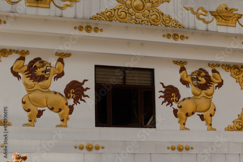 Carved statue of a lion beside the window of the Jamchen Vijaya Stupa, Budhanilkantha, Kathmandu, Nepal photo