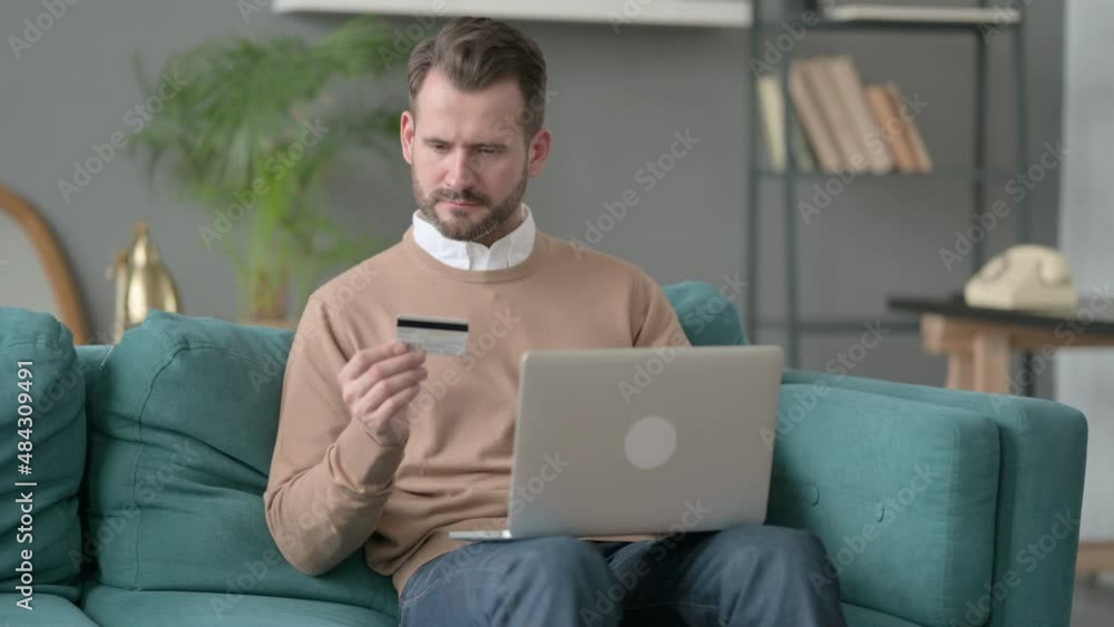 Man with Unsuccessful Online Payment on Laptop on Sofa Man with Unsuccessful Online Payment on Laptop on Sofa