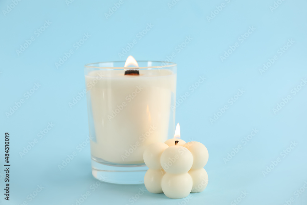 Burning soy candles on light blue background Burning soy candles on light blue background