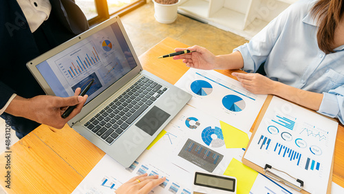 Fototapeta Naklejka Na Ścianę i Meble -  Team meeting to plan a modern and conceptual office design. Hands of businesspeople working on financial graph documents and calculator laptop to discuss the market situation, top view.