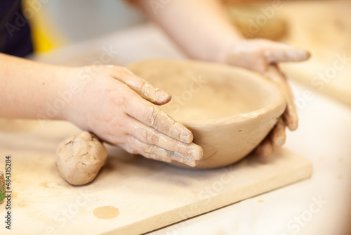 Cute little kid playing with modeling clay in pottery workshop, craft and clay art, child creative activities, education in Arts