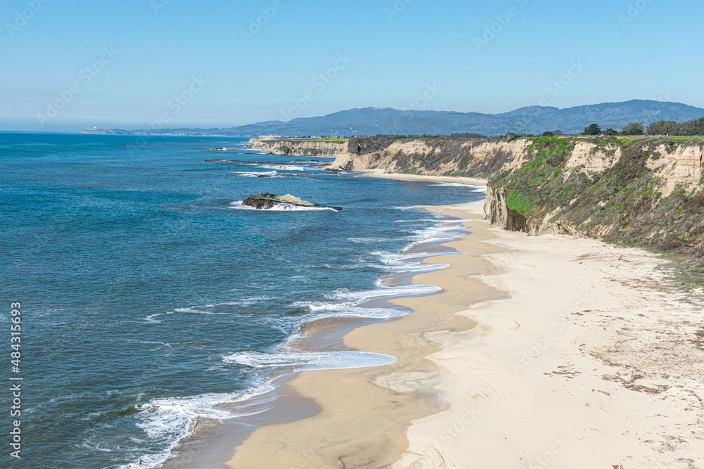 Aerial view of empty sandy beach, rocky outcrops, sandstone cliffs, rocky headlands and Pacific ocean on sunny winter day near Half Moon Bay in California Aerial view of empty sandy beach, rocky outcrops, sandstone cliffs, rocky headlands and Pacific ocean on sunny winter day near Half Moon Bay in California