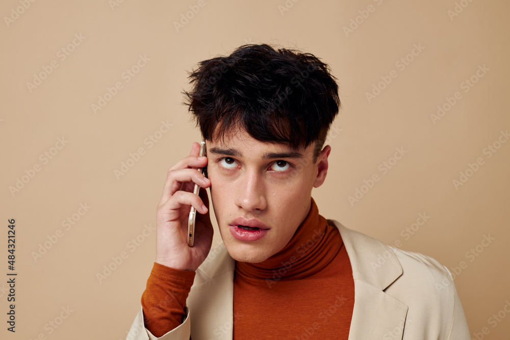 Photo young boyfriend in a beige jacket talking on the phone Lifestyle unaltered Photo young boyfriend in a beige jacket talking on the phone Lifestyle unaltered