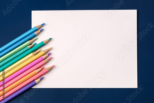 top view paper card with color pastel pencil on navy blue table background