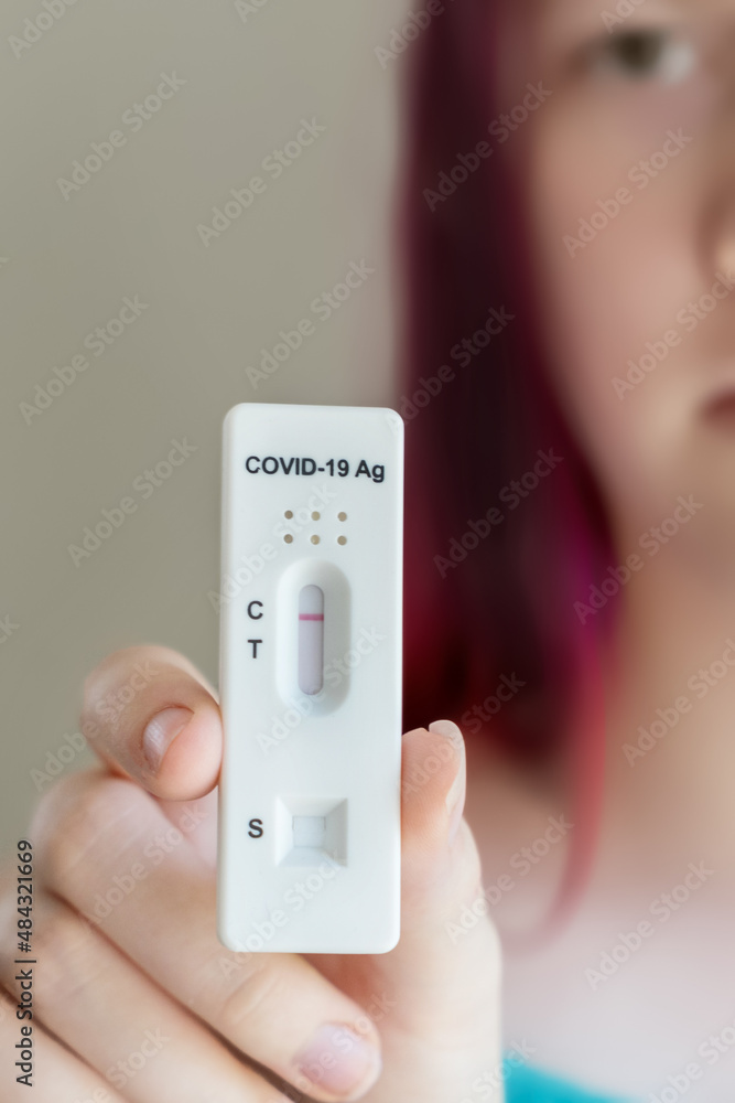 Teenage girl holding Covid-19 rapid antigen test cassette with negative result of rapid diagnostic test Teenage girl holding Covid-19 rapid antigen test cassette with negative result of rapid diagnostic test