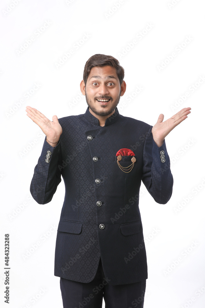young indian man in traditional wear and giving expression on white background. young indian man in traditional wear and giving expression on white background.
