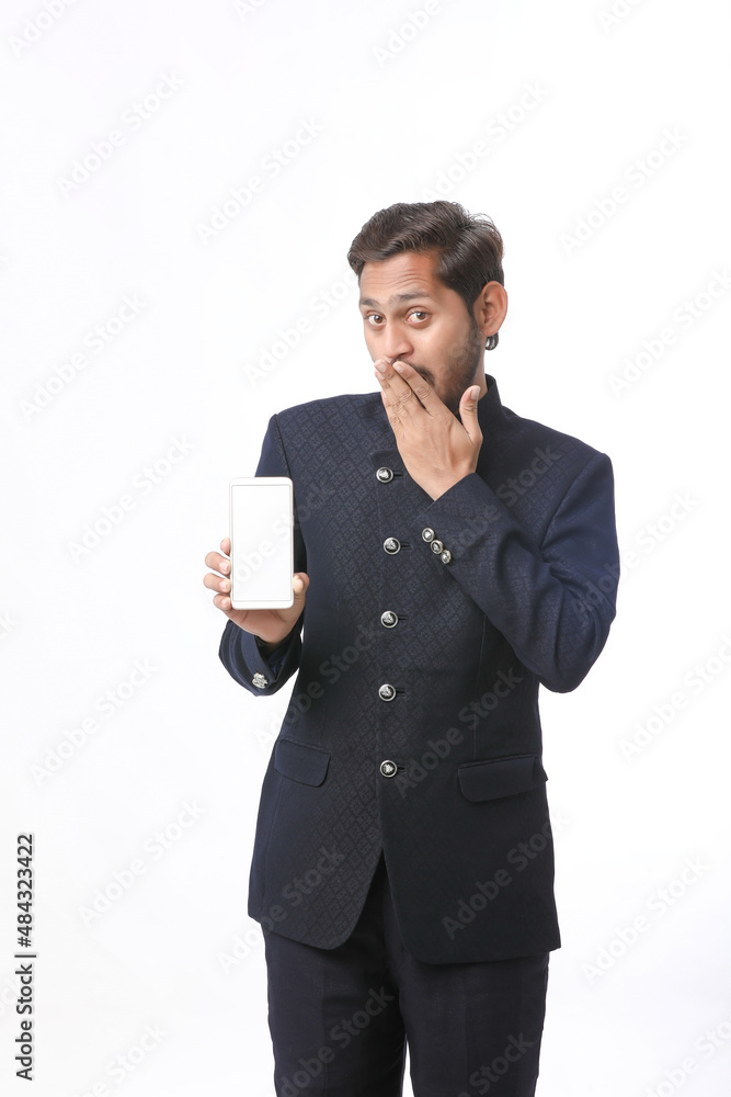 Young indian man in tradition wear and showing smartphone screen on white background. Young indian man in tradition wear and showing smartphone screen on white background.