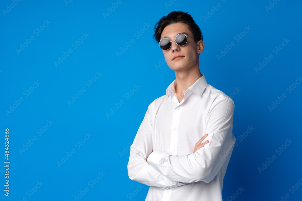Portrait of a smiling teen boy against blue background Portrait of a smiling teen boy against blue background