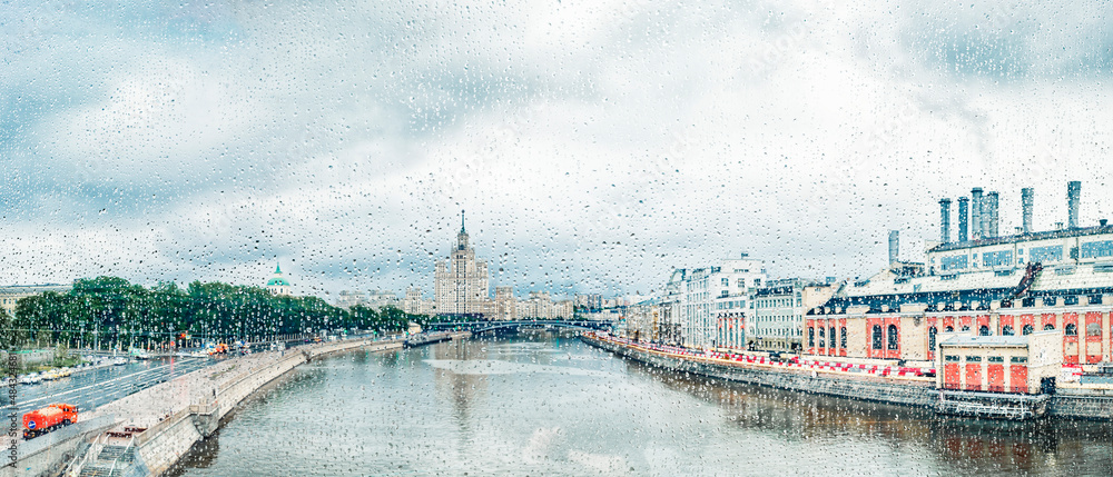 View through glass with raindrops of The Moskva River, Kotelnicheskaya Embankment Building in Moscow, Russia