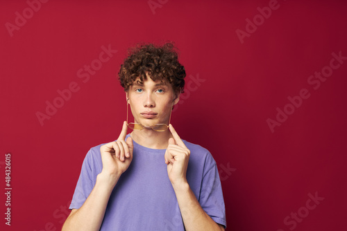 Young curly-haired man posing emotions close-up isolated background