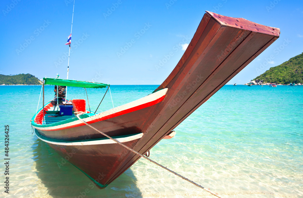 A beautiful thai boat by the shore with a beach