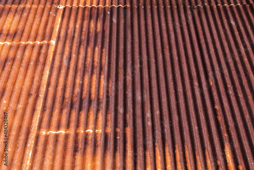 Background photo of a rusty red metal roof slope
