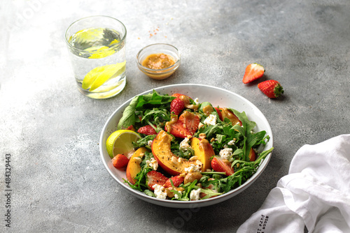 salad bowl with arugula, strawberry, cottage cheese, nectarine and peanut paste. healthy eating concept © виктория статных