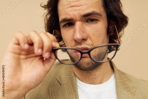 Cheerful man with glasses emotions gesture hands posing beige background