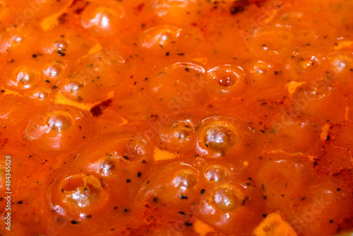 Kochende rote Tomaten-Sauce (für Nudeln) blubbert bei der Zubereitung in der Küche in einem Topf (Details / Nahaufnahme)