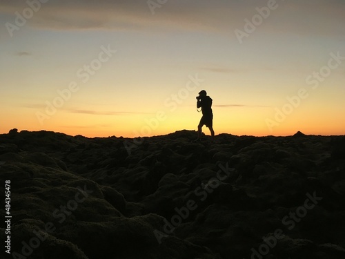 Photographer taking pics at sunset. Person shape at sunset. Iceland 