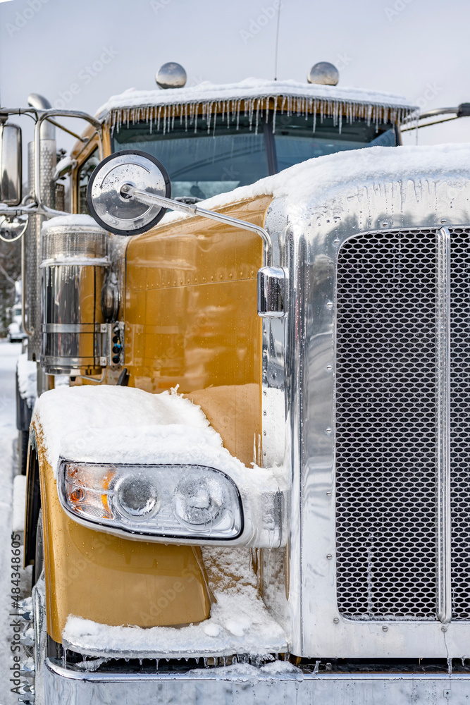 Gold stylish big rig semi truck with chrome accessories standing on the