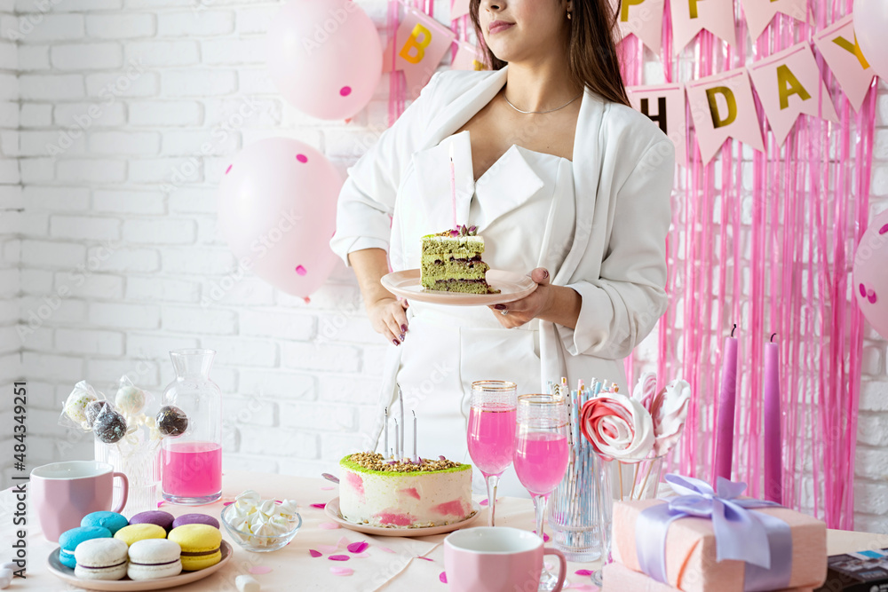 Beautiful woman celebrating birthday party holding a piece of cake making wish Beautiful woman celebrating birthday party holding a piece of cake making wish