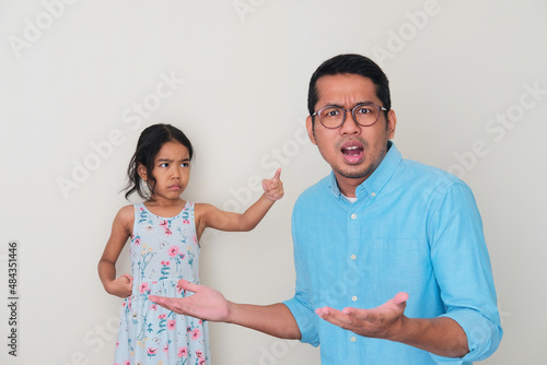 Asian little kid pointing her father with angry expression photo